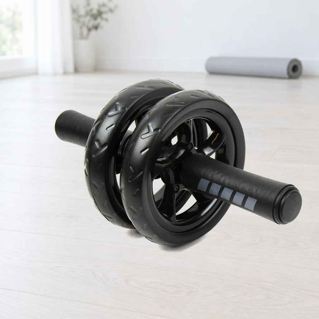 Ab wheel met twee zwarte wielen met profiel en foamgrepen met grijze strepen, op een lichte houten vloer