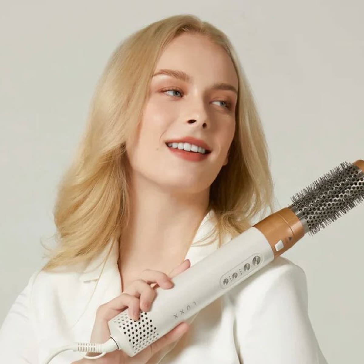 De airstyler in de hand met de ronde borstel erop