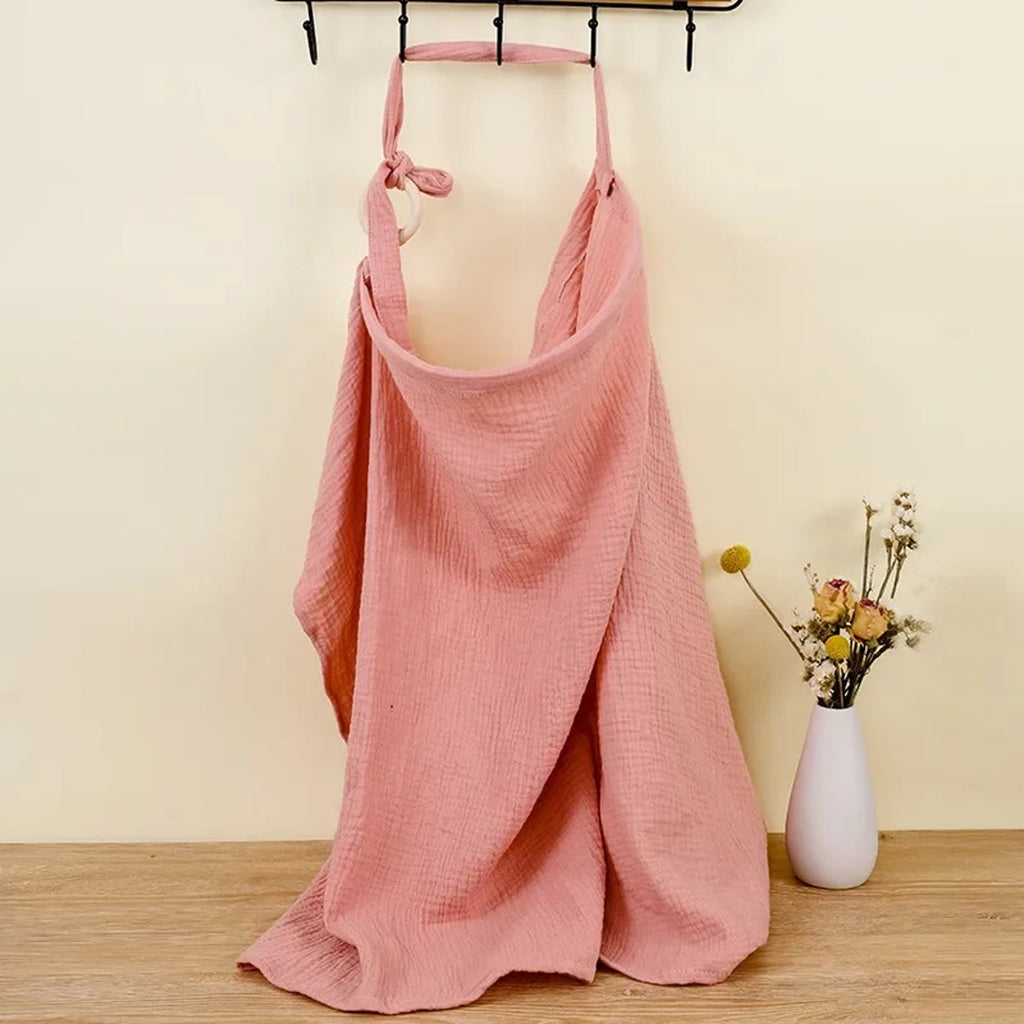 Roze borstvoedingsdoek van katoenen mousseline, hangend aan een kapstok