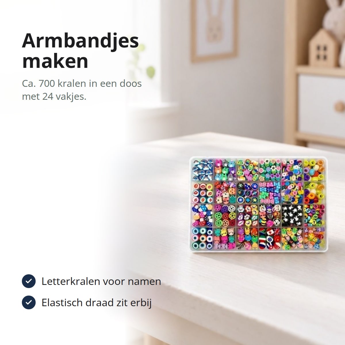 Kralenset in een sorteerdoos met 24 vakjes op een wit bureau, met de tekst: armbandjes maken, ca. 700 kralen in een doos met 24 vakjes, letterkralen voor namen, elastisch draad zit erbij