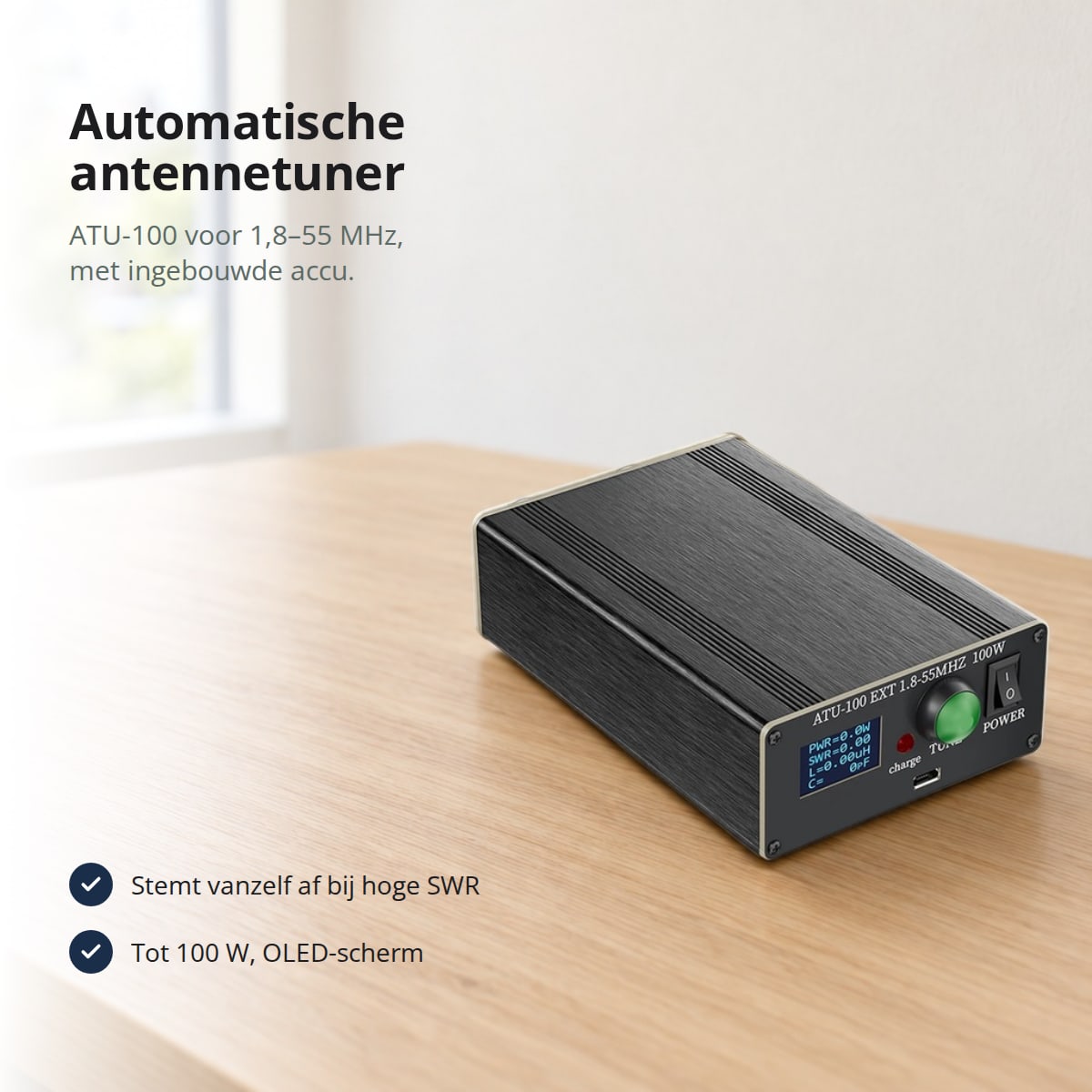 Automatische antennetuner ATU-100 voor 1,8–55 MHz met ingebouwde accu, op een houten bureau bij het raam