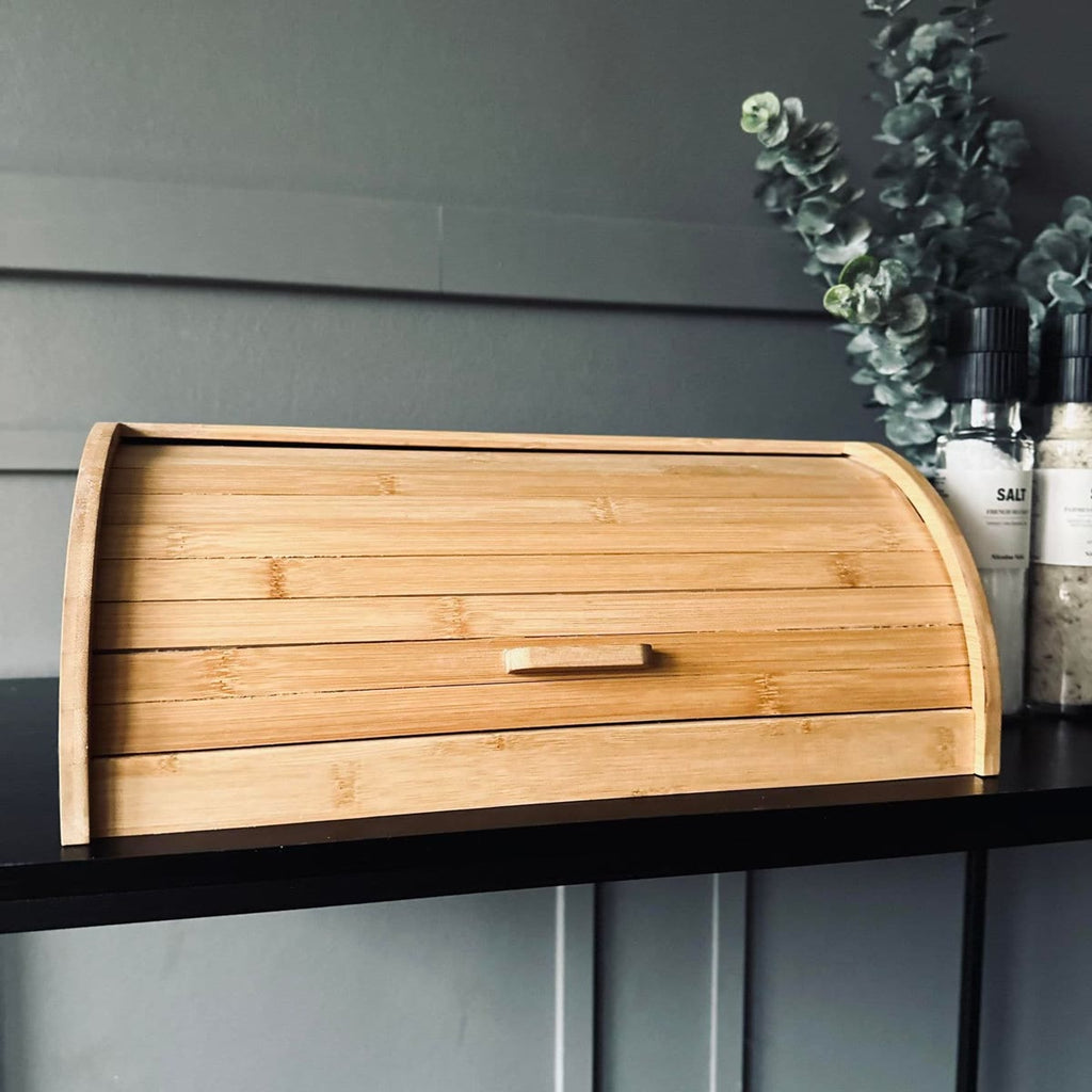 De broodtrommel dicht op een zwarte plank tegen een grijze lambrisering, met eucalyptus erachter
