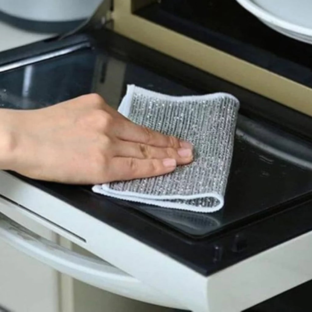 Hand maakt de ovenruit schoon met een draadvaatdoekje