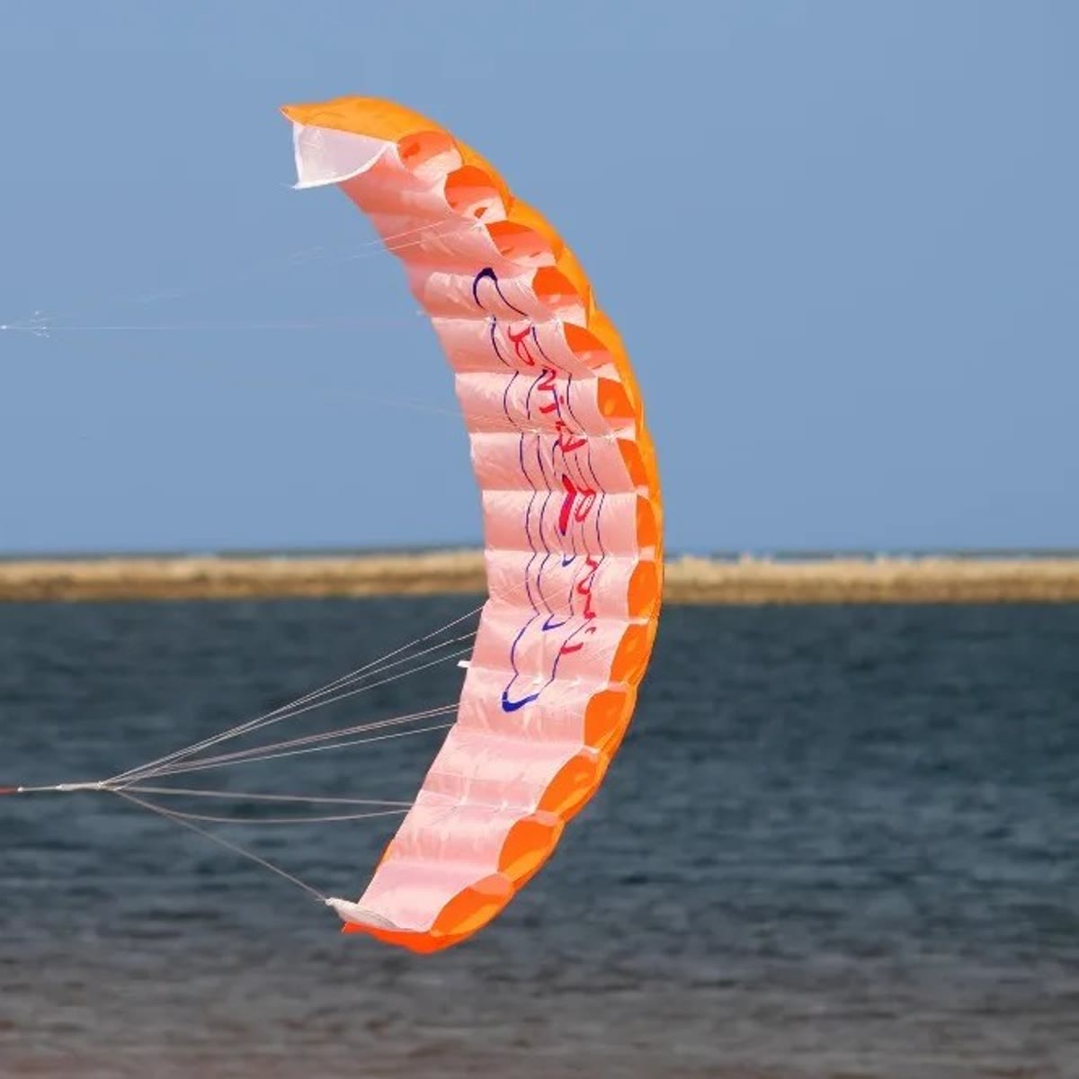 De oranje vlieger laag boven de zee, van opzij gezien met strakke lijnen
