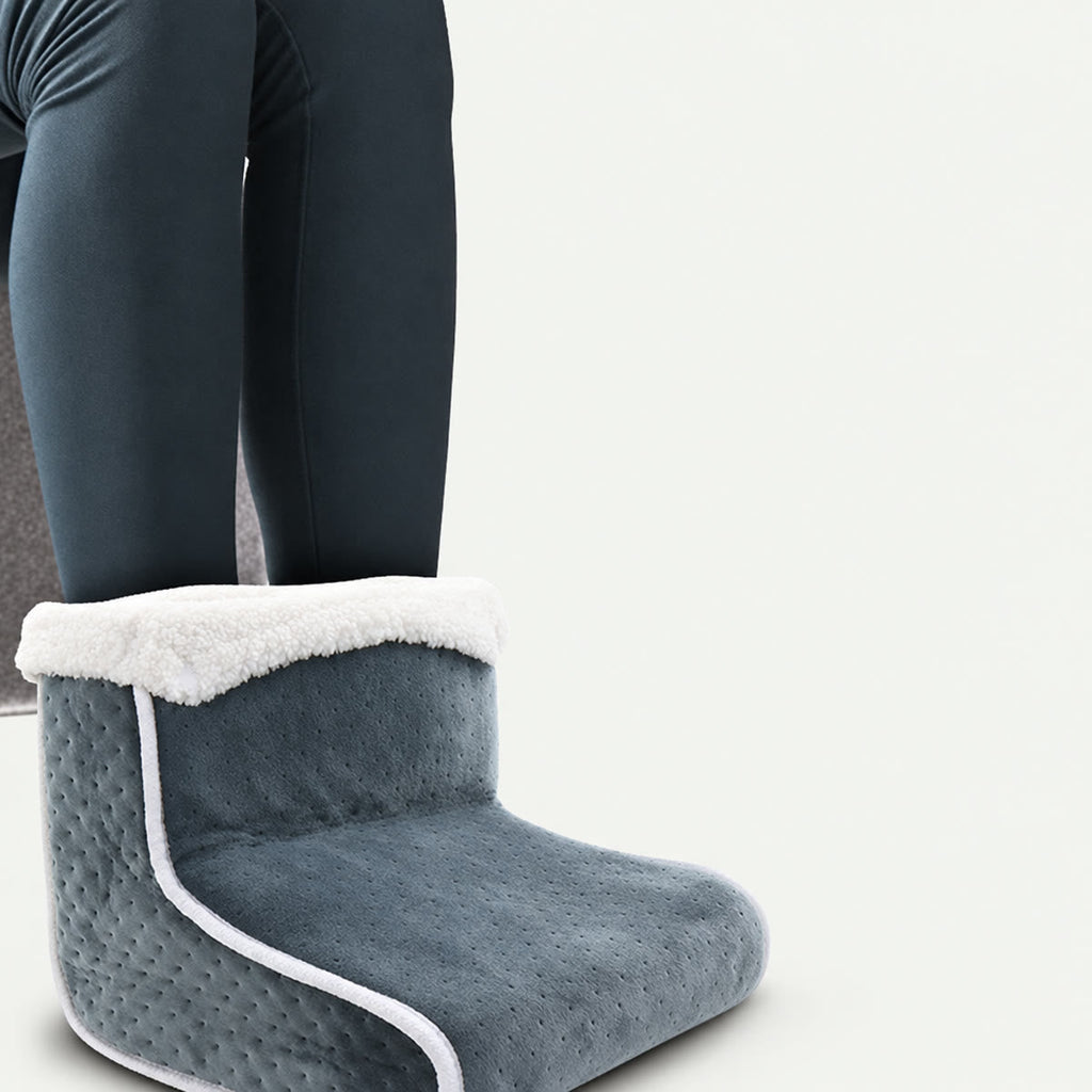 Benen in een donkere panty met de voeten in de voetenwarmer