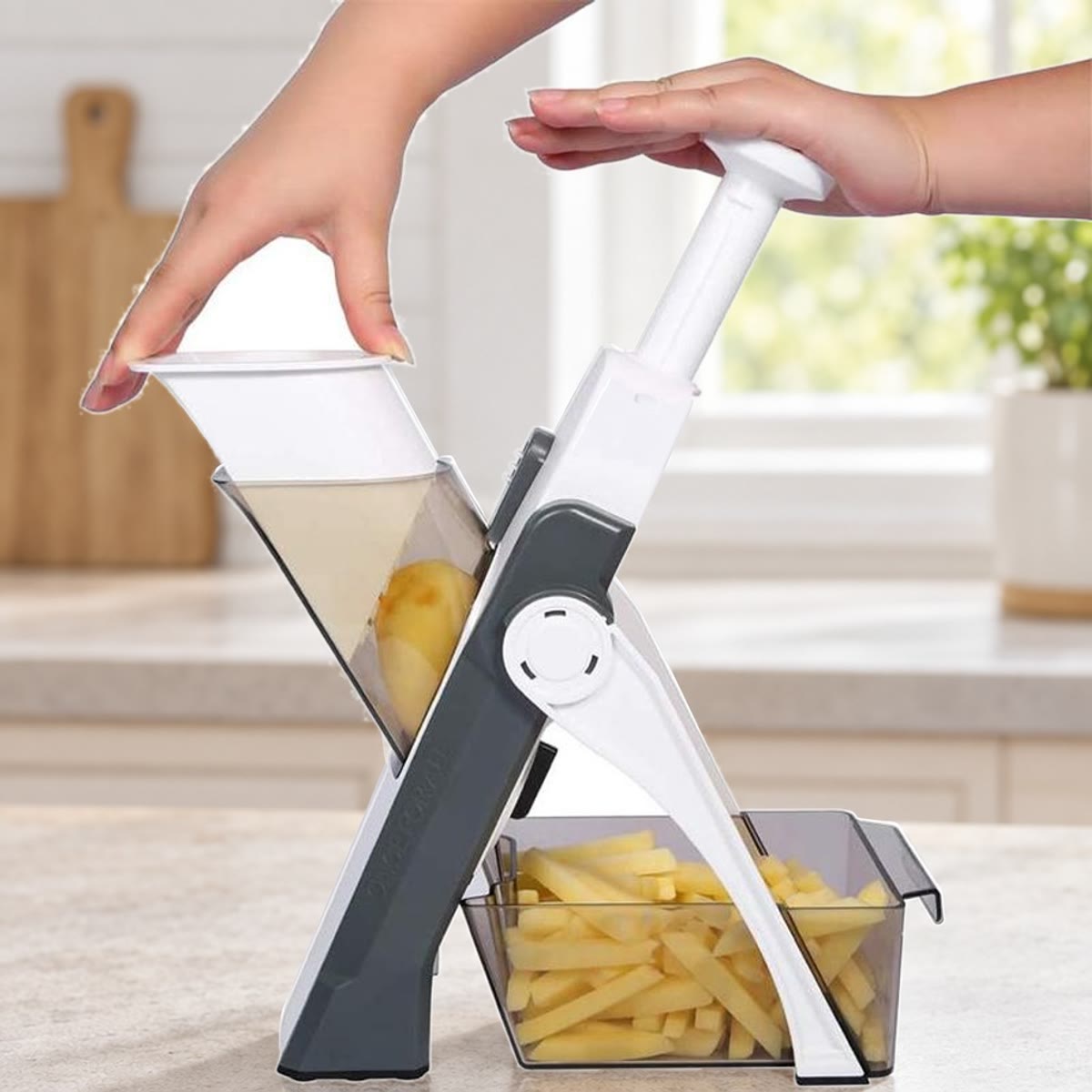 Grijze groentesnijder op een aanrecht met frietjes in de opvangbak