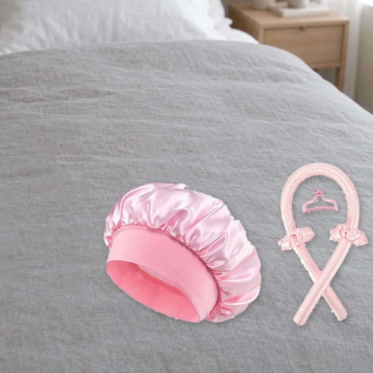 Roze krulstaaf en satijnen muts op een bed, klaar voor gebruik 's avonds
