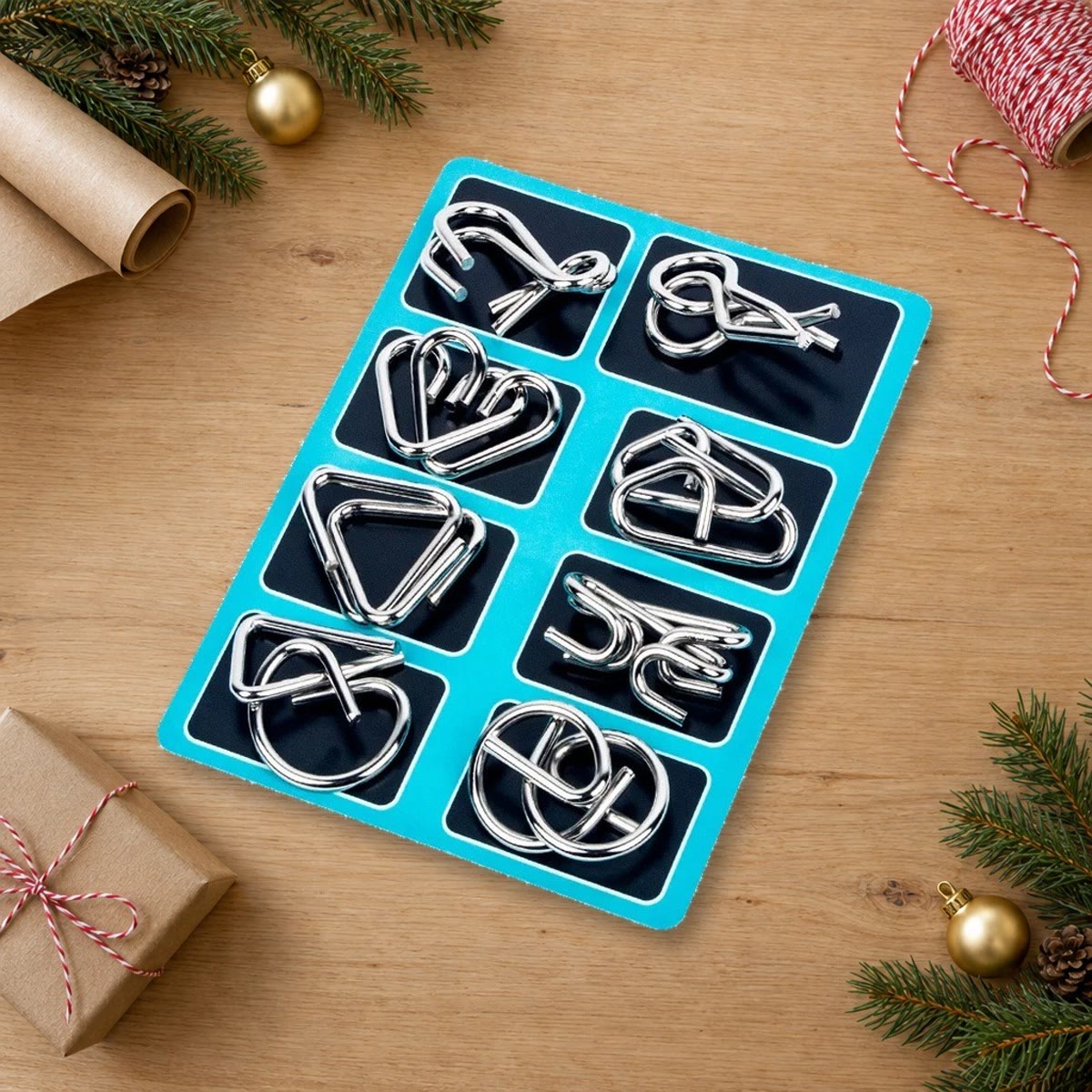 Breinbrekers van metaal op een blauw bord naast kerstpapier, dennentakken en een klein cadeautje op een houten tafel