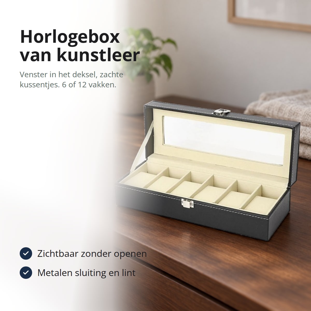 Horlogebox van zwart kunstleer met zes kussentjes en open vensterdeksel op een ladekast, met de tekst: horlogebox van kunstleer, venster in het deksel, zachte kussentjes, 6 of 12 vakken; zichtbaar zonder openen; metalen sluiting en lint