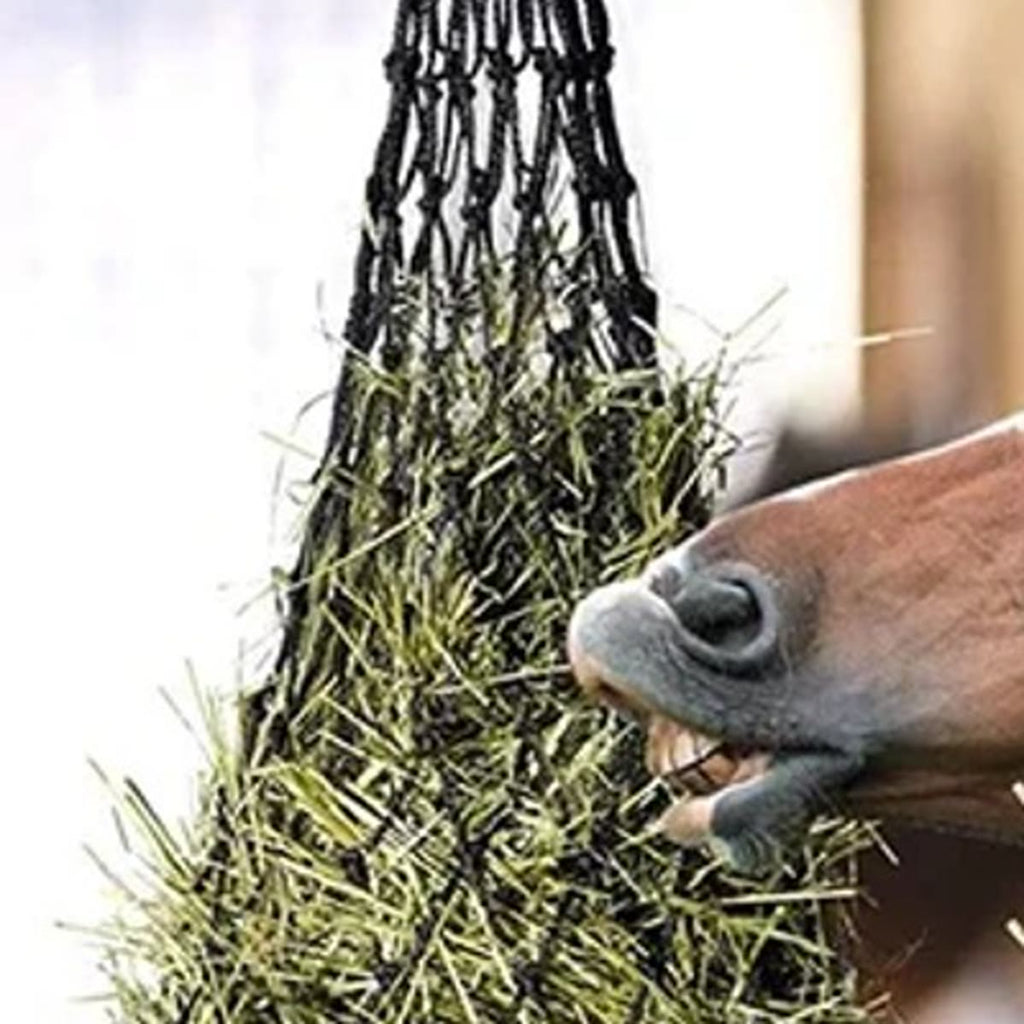 Close-up van een zwart hooinet met ringen bovenaan en een paard dat hooi door de mazen plukt