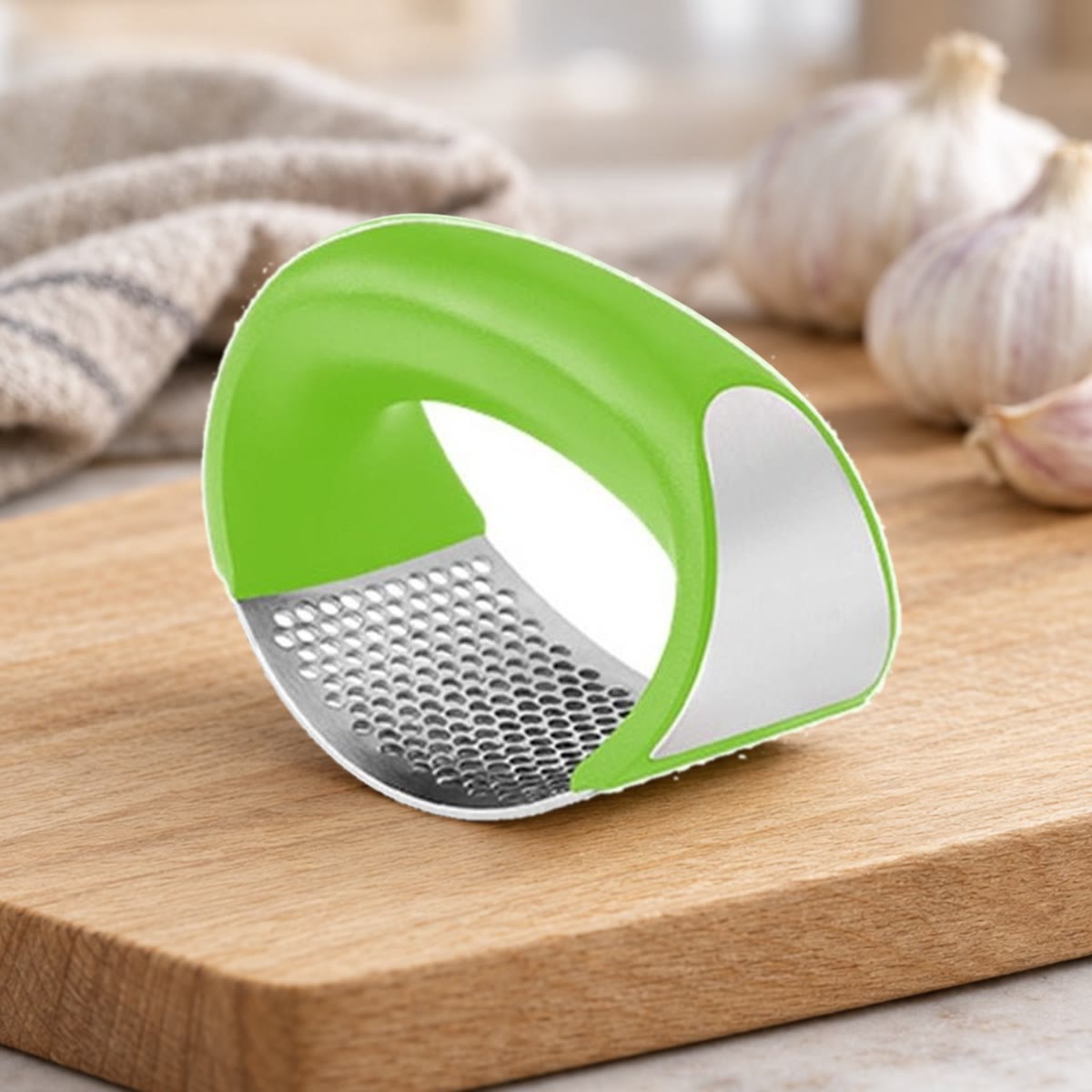 Groene knoflookpers met gebogen stalen plaat op een eikenhouten snijplank