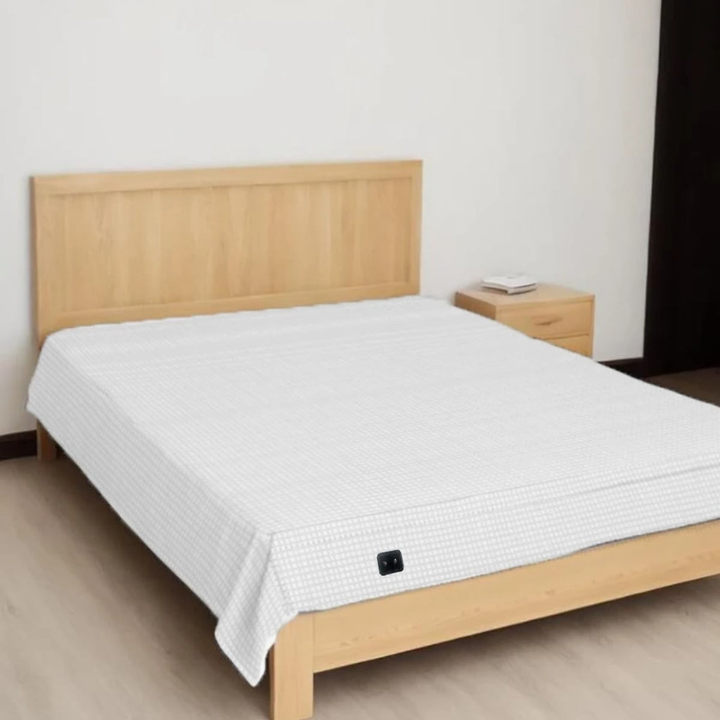 Aardingslaken over een bed met een hoofdeinde van licht hout, met het zwarte aansluitlapje aan het voeteneinde