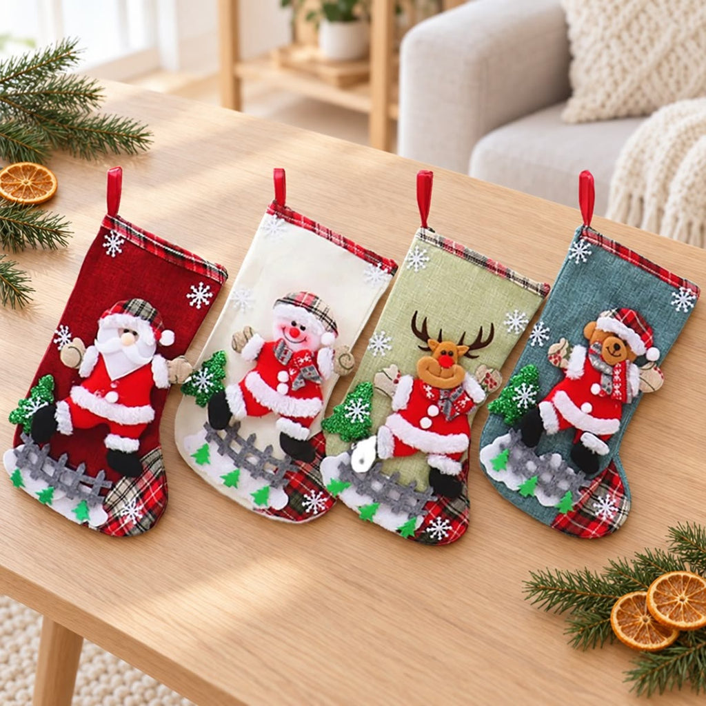 De vier kerstsokken naast elkaar op een lichte eikenhouten tafel met dennentakken en sinaasappelschijfjes