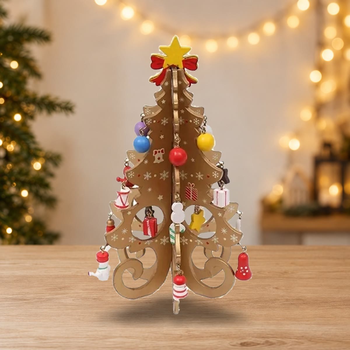 Goudkleurige houten kerstboom met kleine houten versieringen op een houten tafel voor kerstlichtjes