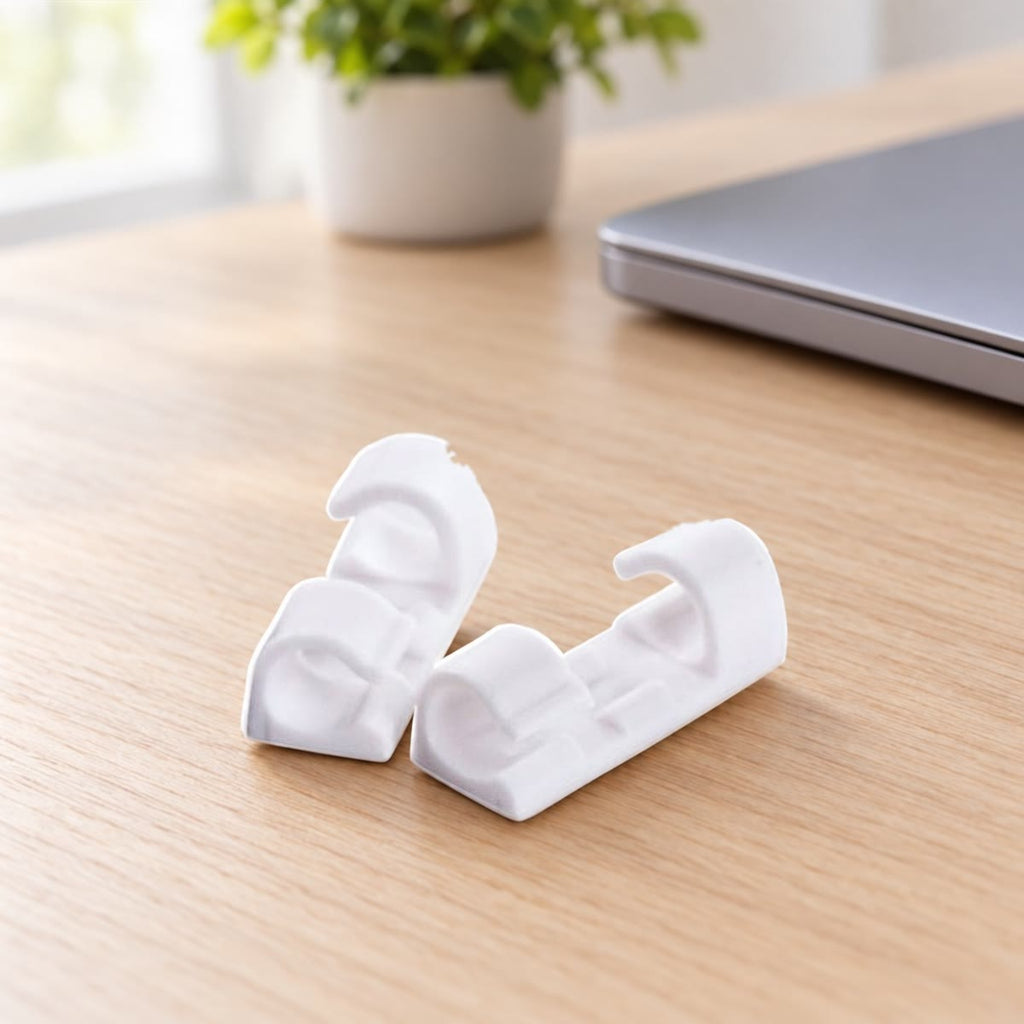 Witte kabelclips rechtop op een licht bureau