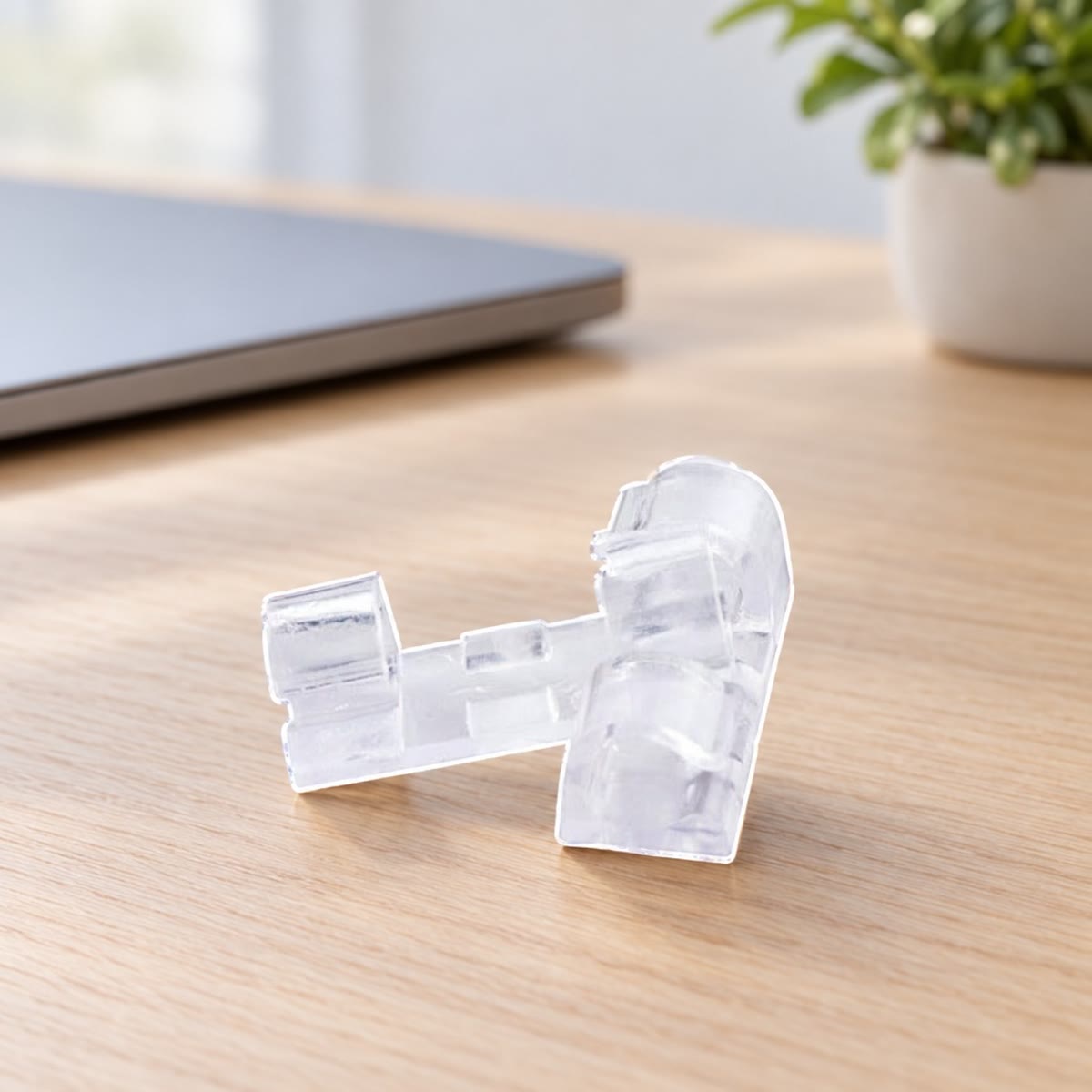 Transparante kabelclips op een eikenhouten bureau