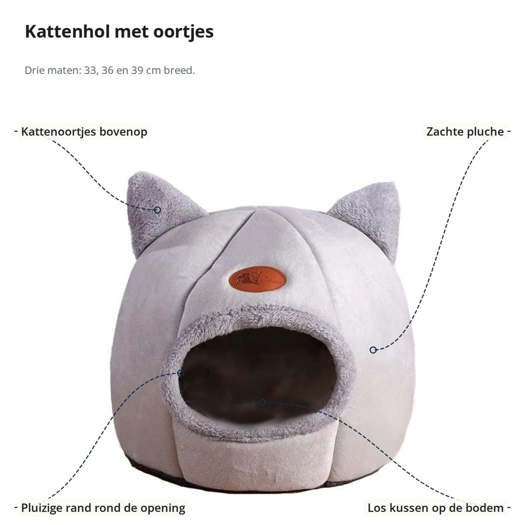 Lichtgrijs kattenhol met aanduidingen: kattenoortjes bovenop, zachte pluche, pluizige rand rond de opening en los kussen op de bodem