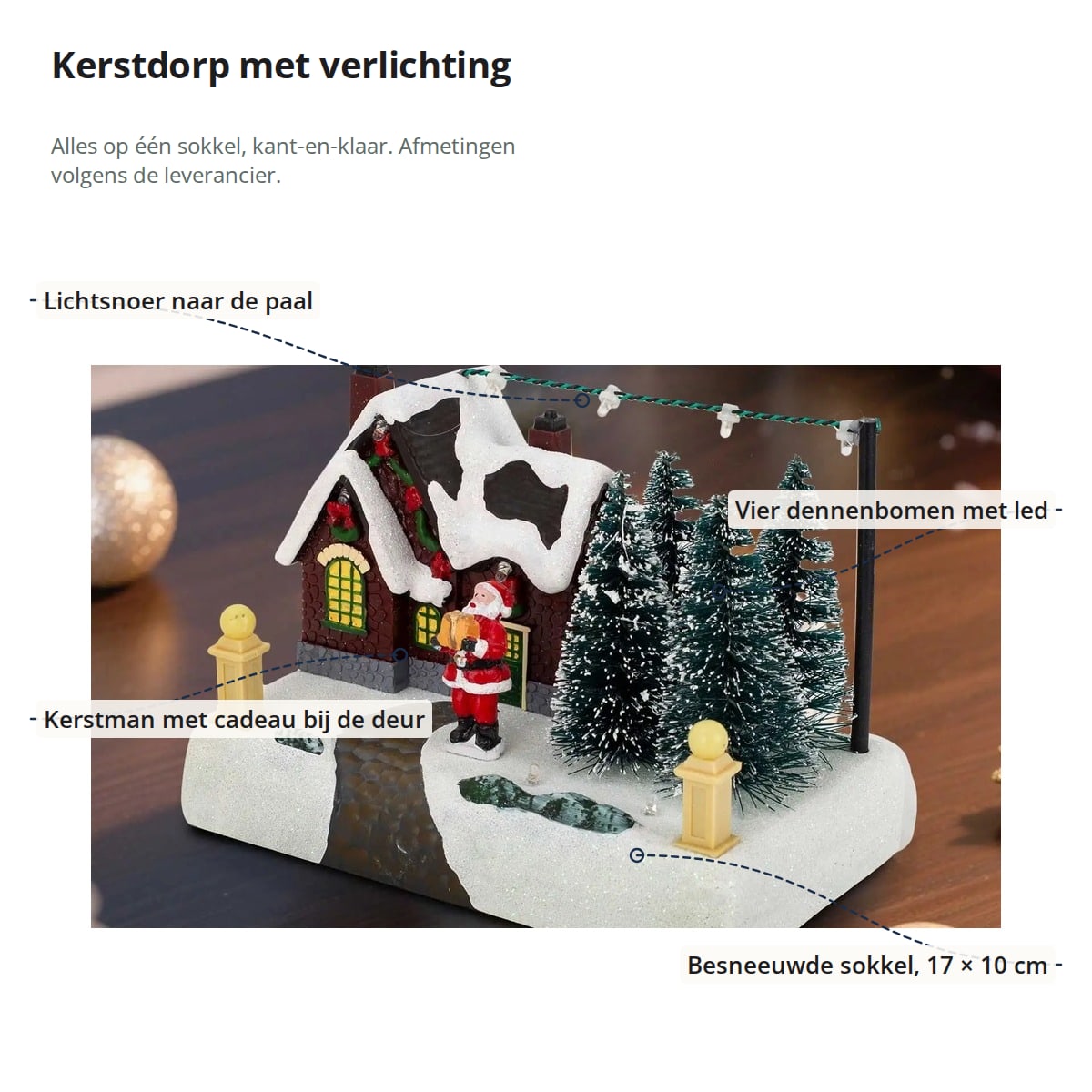 Het kerstdorp met aanduidingen: lichtsnoer naar de paal, vier dennenbomen met led, kerstman met cadeau bij de deur en besneeuwde sokkel van 17 × 10 cm