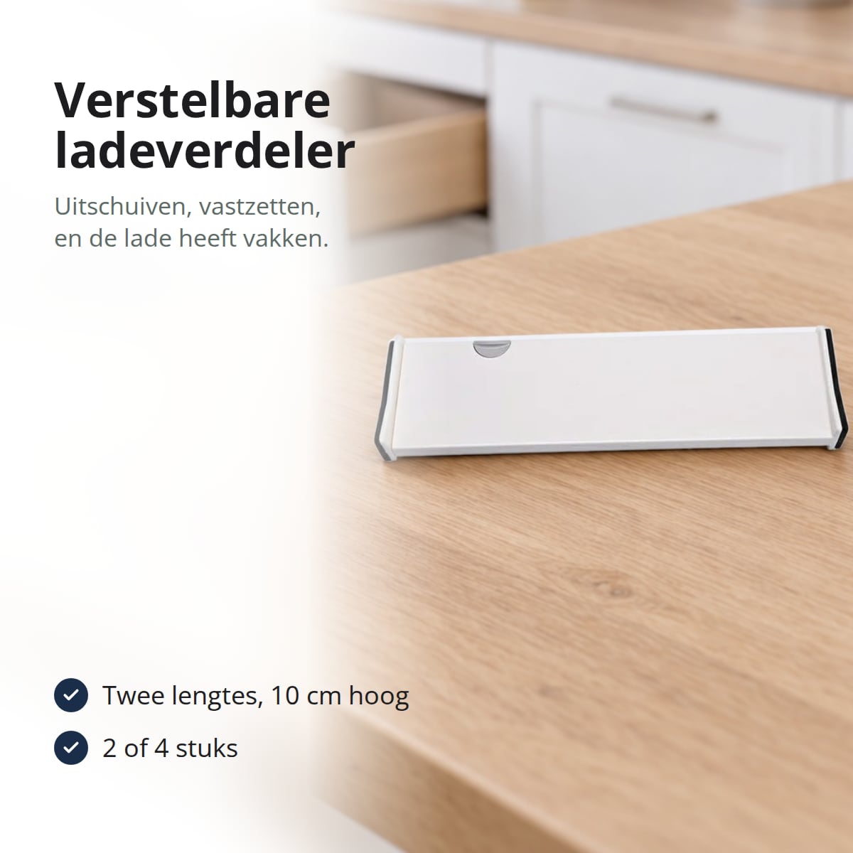 Witte verstelbare ladeverdeler op een werkblad van licht hout voor een open keukenlade