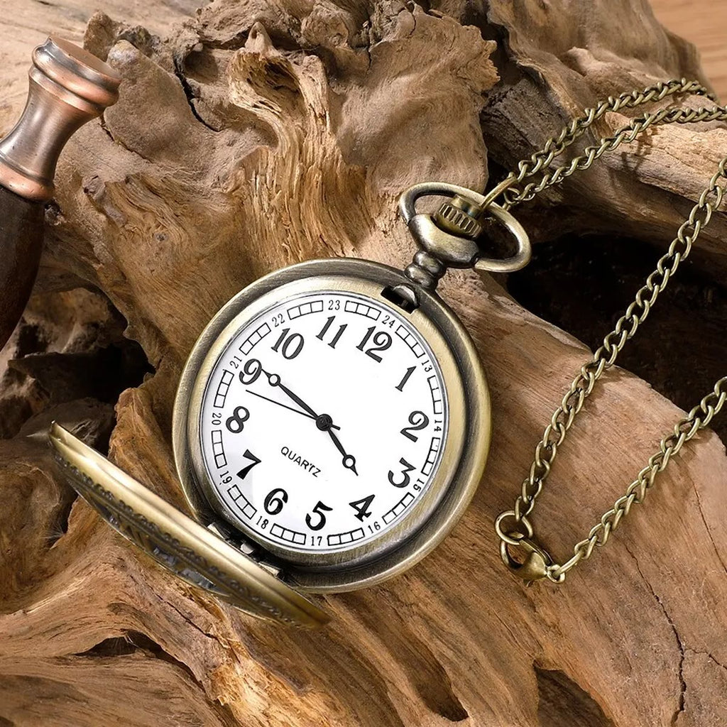 Open zakhorloge met kwartsuurwerk, leunend tegen drijfhout, met de ketting ernaast