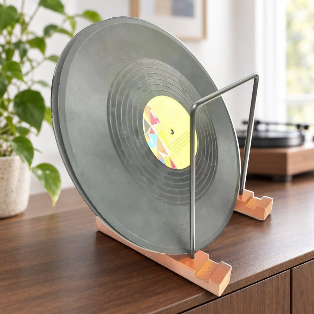 Vinylplaat rechtop in een LP standaard met houten voetjes en zwarte metalen frames op een notenhouten dressoir