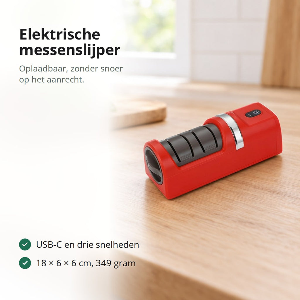 Rode elektrische messenslijper op een eiken aanrecht, met een snijplank, tomaten en basilicum op de achtergrond