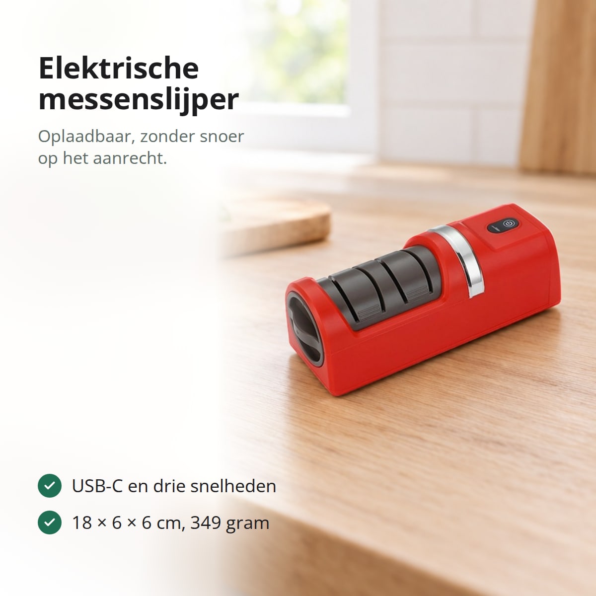 Rode elektrische messenslijper op een eiken aanrecht, met een snijplank, tomaten en basilicum op de achtergrond
