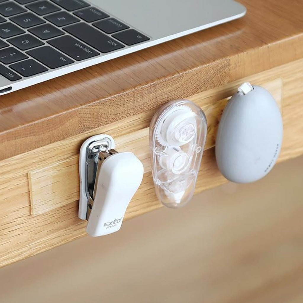 Nietmachine, correctieroller en muiskabel met nano tape aan de zijkant van een bureau bevestigd