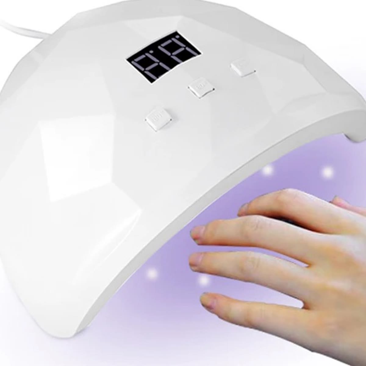 Hand onder een witte nagellamp met het licht aan