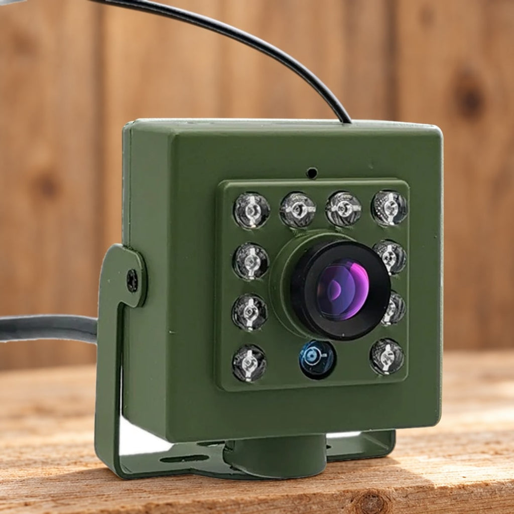 Nestkastcamera met infraroodleds rond de lens op een ruwe houten plank voor een houten wand