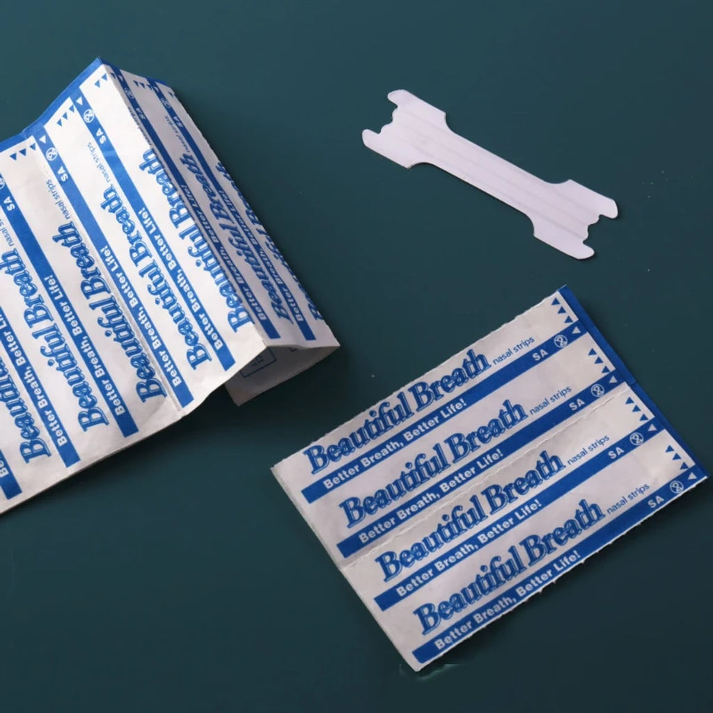 Transparante neusstrip naast de per stuk verpakte zakjes op een donkergroene ondergrond