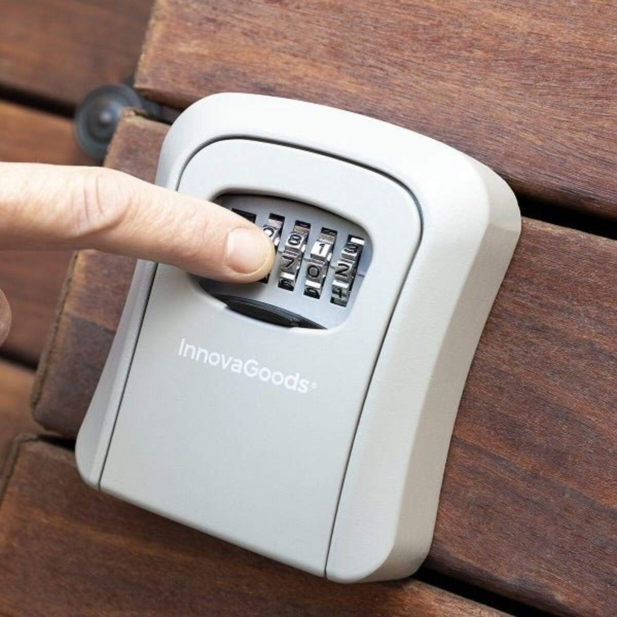 Vinger die de viercijferige code op de sleutelkluis instelt