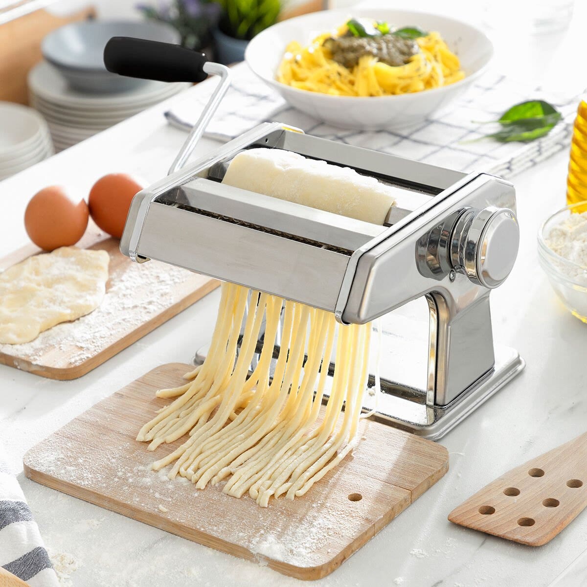Tagliatelle komt uit de roller en valt op een houten plank