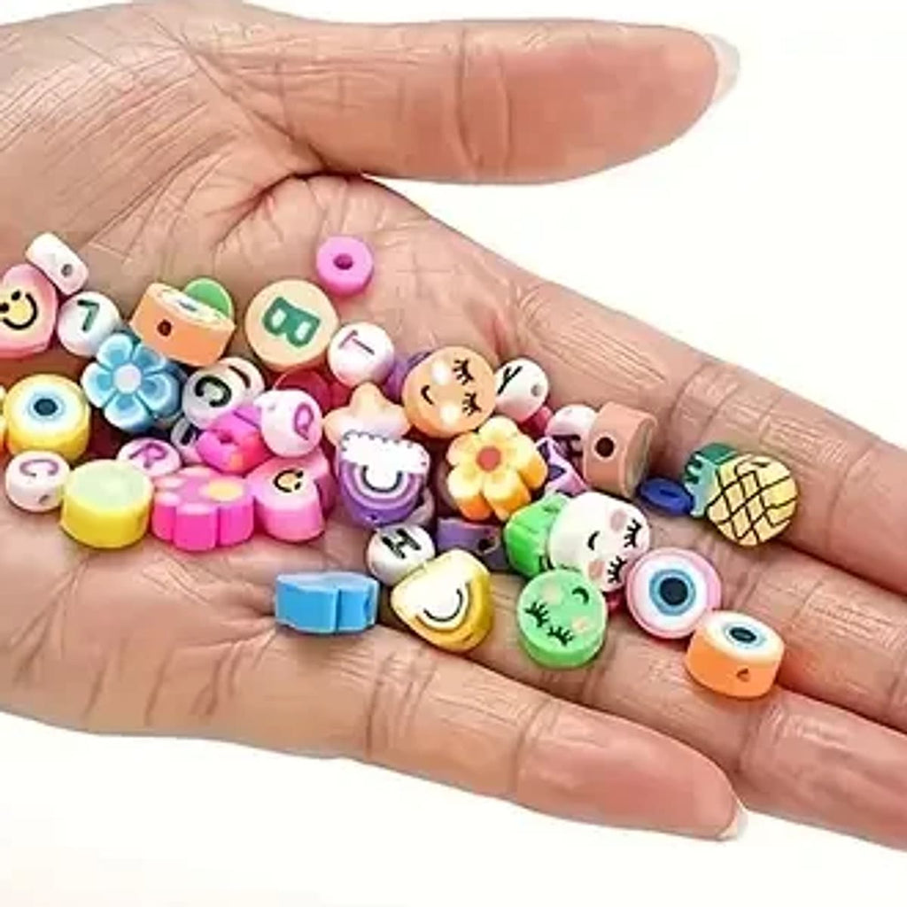 Kleikralen met motiefjes en kleine kleischijfjes in een hand, die laten zien hoe klein de kralen zijn; de motiefjes in de set kunnen verschillen