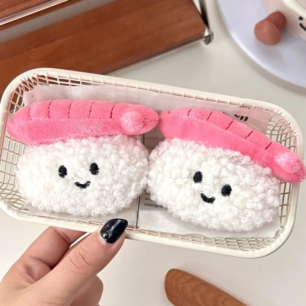 Twee pluche sushi-sleutelhangers met een glimlach in een mandje