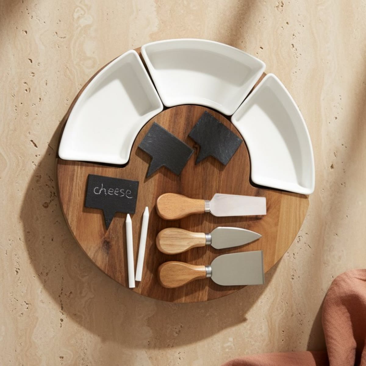 De plank met lege schaaltjes en leistenen bordjes op een stenen tafel