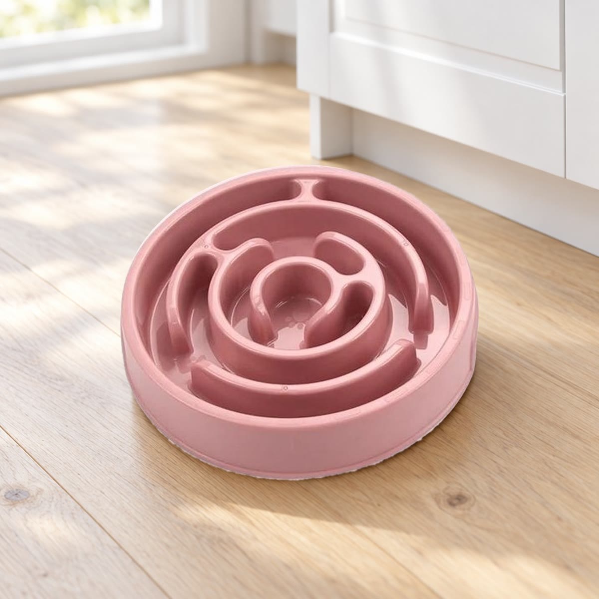 Roze anti-schrokbak met labyrintpatroon op een houten keukenvloer