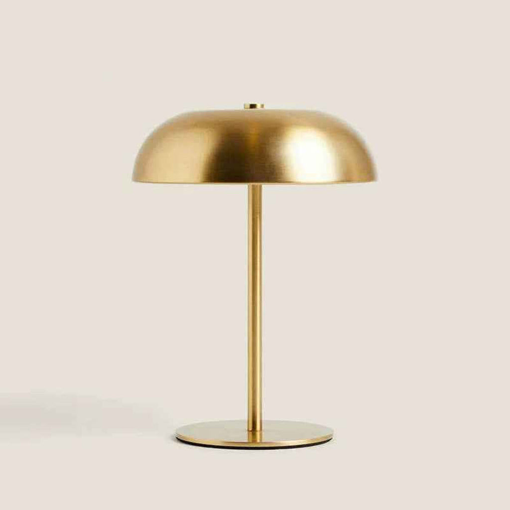 Mushroom lamp in goud op een beige achtergrond