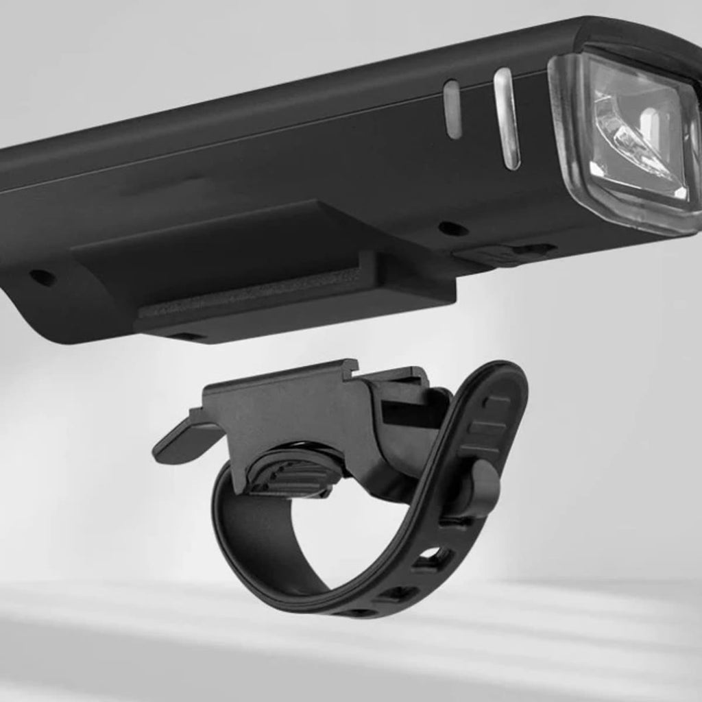 De fietslamp en de houder met rubberen band die je zonder gereedschap om het stuur vastmaakt