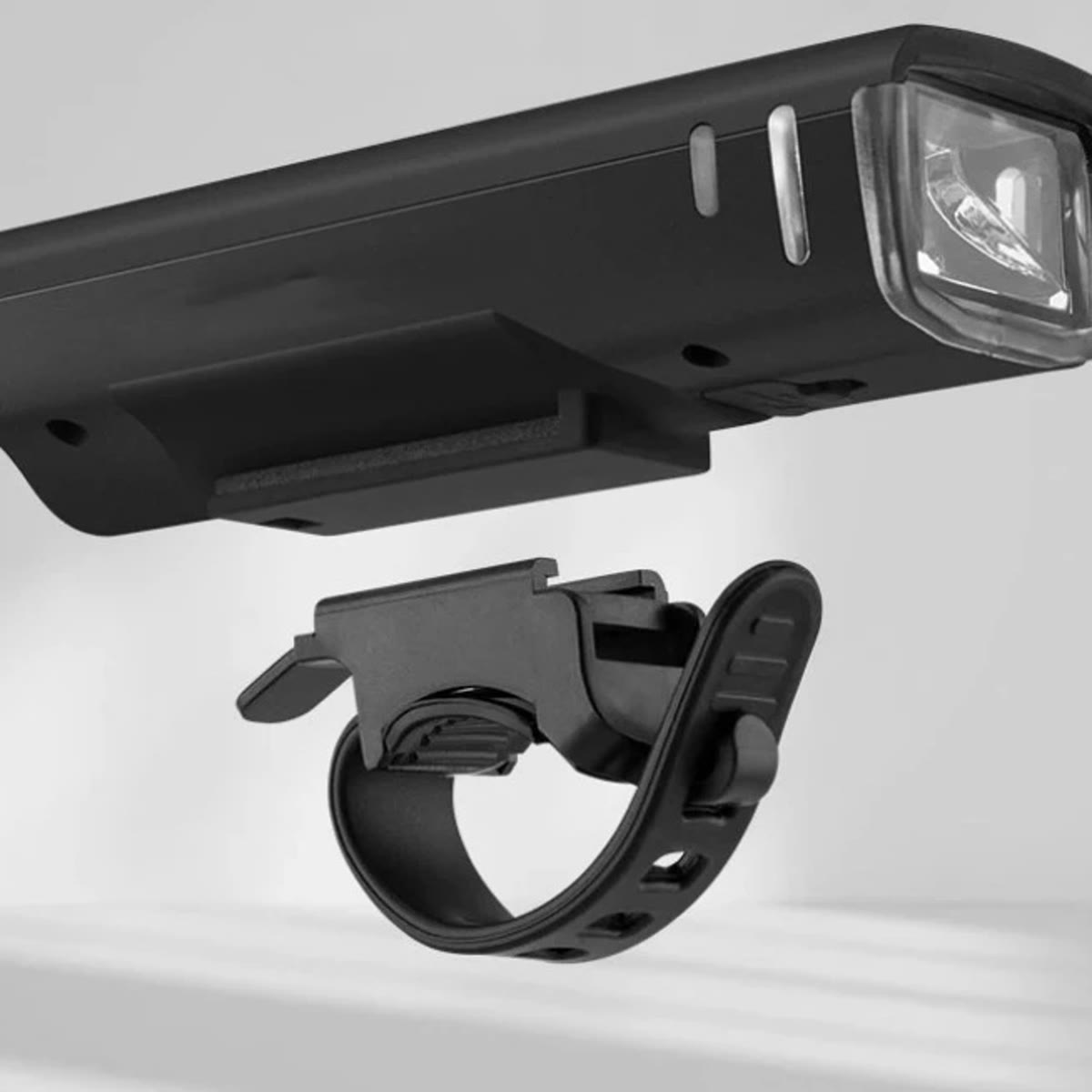 De fietslamp en de houder met rubberen band die je zonder gereedschap om het stuur vastmaakt
