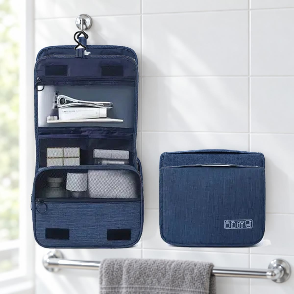 Marineblauwe hangende toilettas, uitgevouwen en dicht, tegen een witte tegelwand in de badkamer