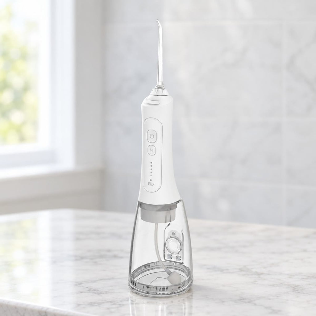 Witte draadloze waterflosser met gebogen opzetstuk en doorzichtig reservoir op een marmeren badkamerblad