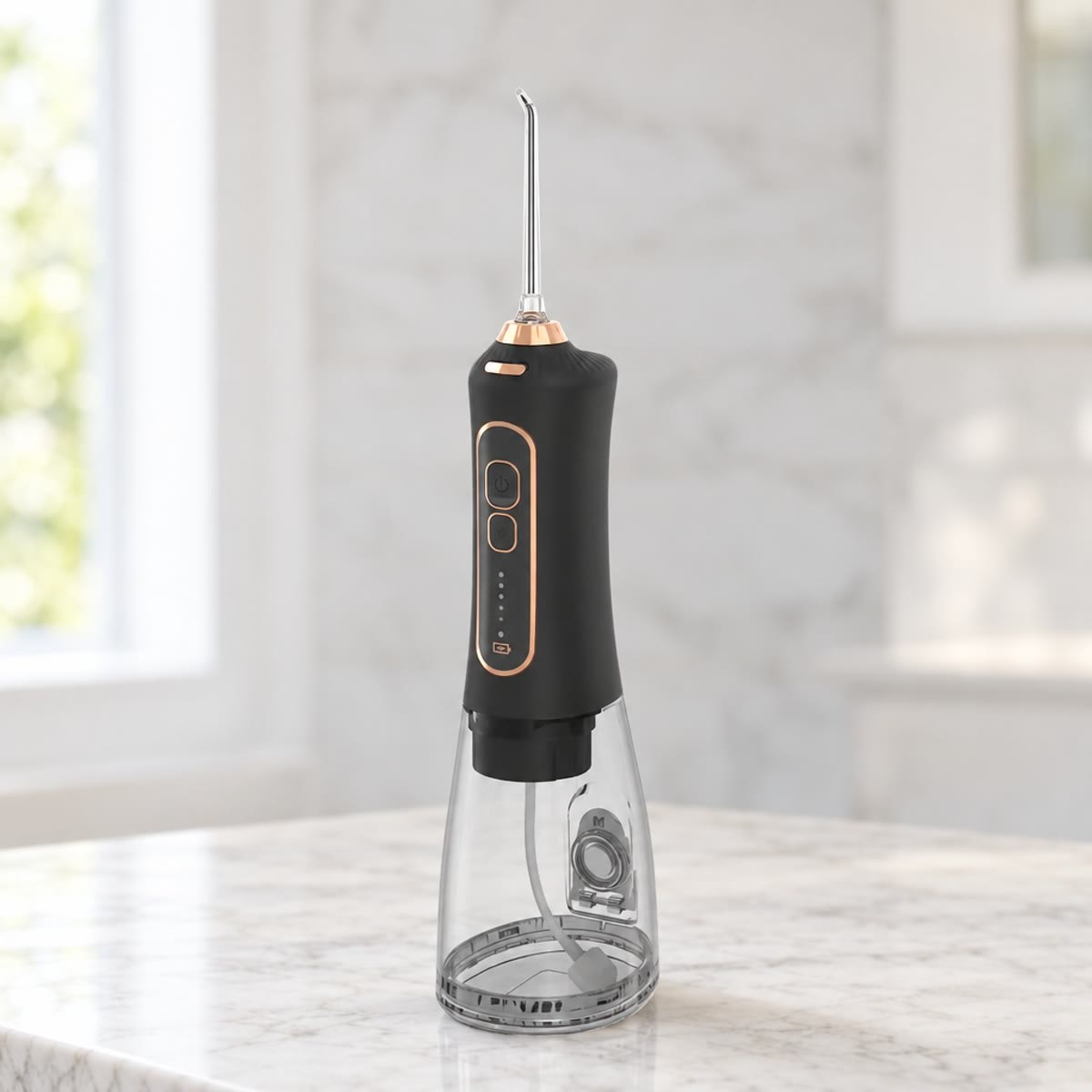 Zwarte draadloze waterflosser met goudkleurige ring en doorzichtig waterreservoir op een marmeren blad