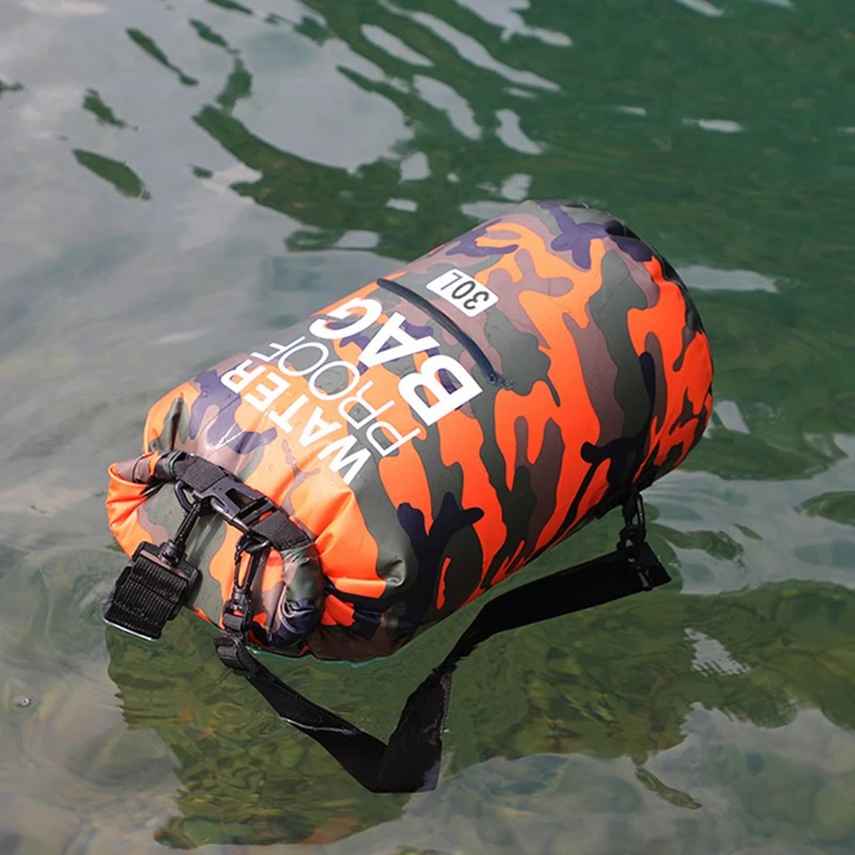 Waterdichte rugzak in oranje camouflage die met gesloten roltop op het water drijft