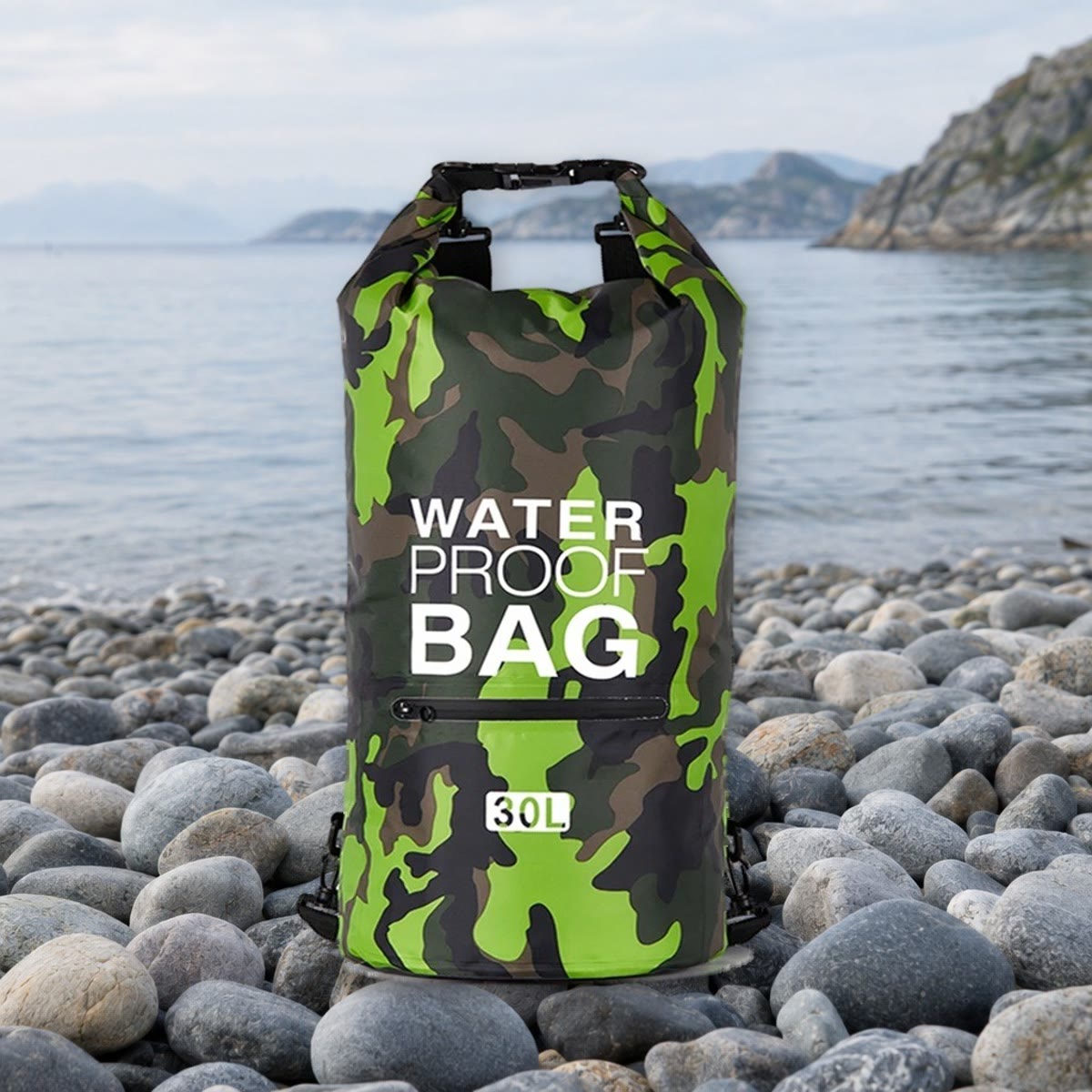 Waterdichte rugzak in groene camouflage met voorvak op een kiezelstrand