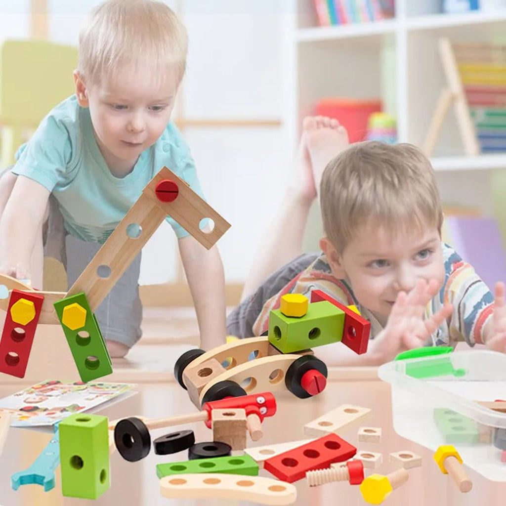 Twee kinderen die op de vloer bouwen met houten plankjes, schroeven en wieltjes