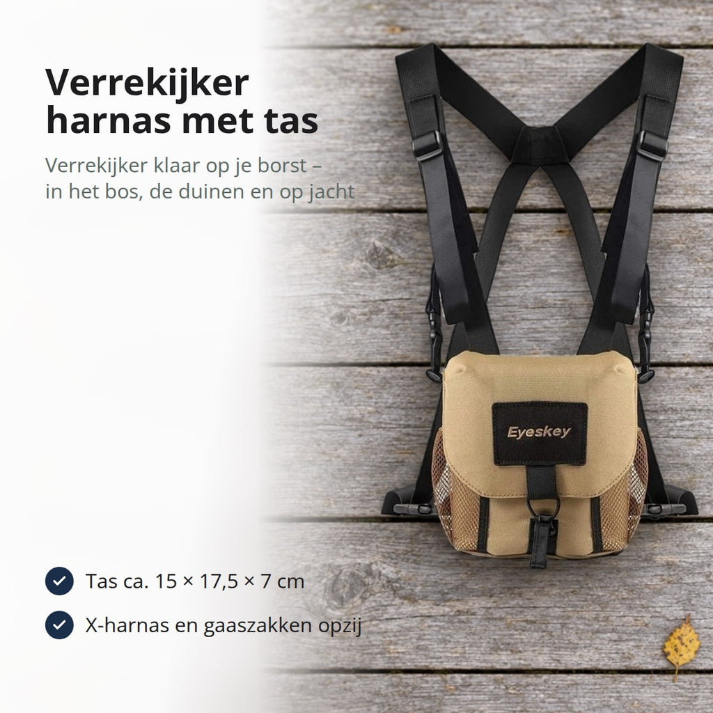 Verrekijker harnas met zandkleurige tas en zwarte X-vormige riemen op grijze houten vlonderplanken met gele berkenbladeren, met de tekst: verrekijker harnas met tas, je verrekijker klaar op je borst in het bos, de duinen en op jacht; tas ca. 15 × 17,5 × 7 cm, X-harnas en gaaszakken opzij