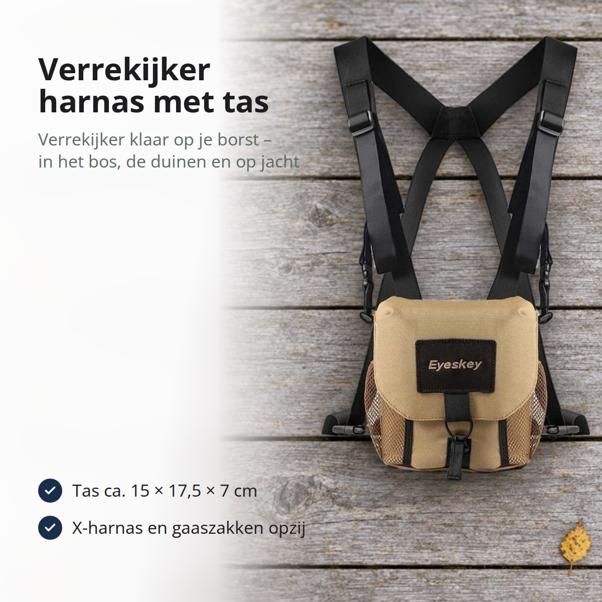 Verrekijker harnas met zandkleurige tas en zwarte X-vormige riemen op grijze houten vlonderplanken met gele berkenbladeren, met de tekst: verrekijker harnas met tas, je verrekijker klaar op je borst in het bos, de duinen en op jacht; tas ca. 15 × 17,5 × 7 cm, X-harnas en gaaszakken opzij