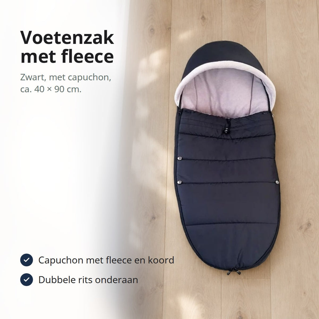 Zwarte voetenzak met lichte fleecevoering en capuchon op een eikenhouten vloer, met de tekst: voetenzak met fleece, zwart, met capuchon, ca. 40 × 90 cm, capuchon met fleece en koord, dubbele rits onderaan