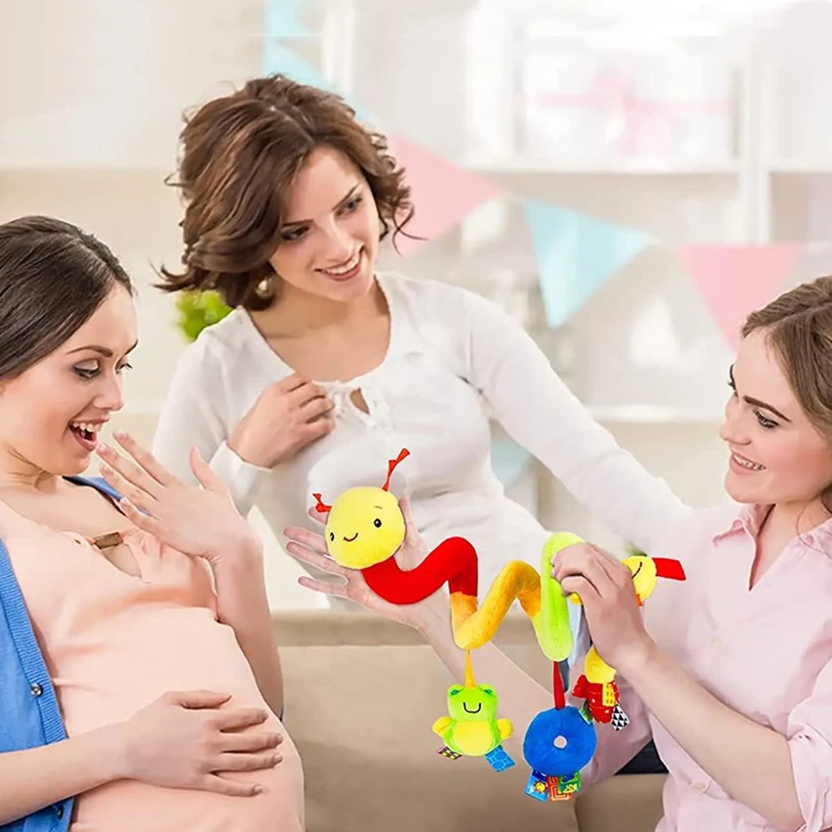 Wagenspanner als cadeau voor een zwangere vrouw, omhooggehouden door een vriendin